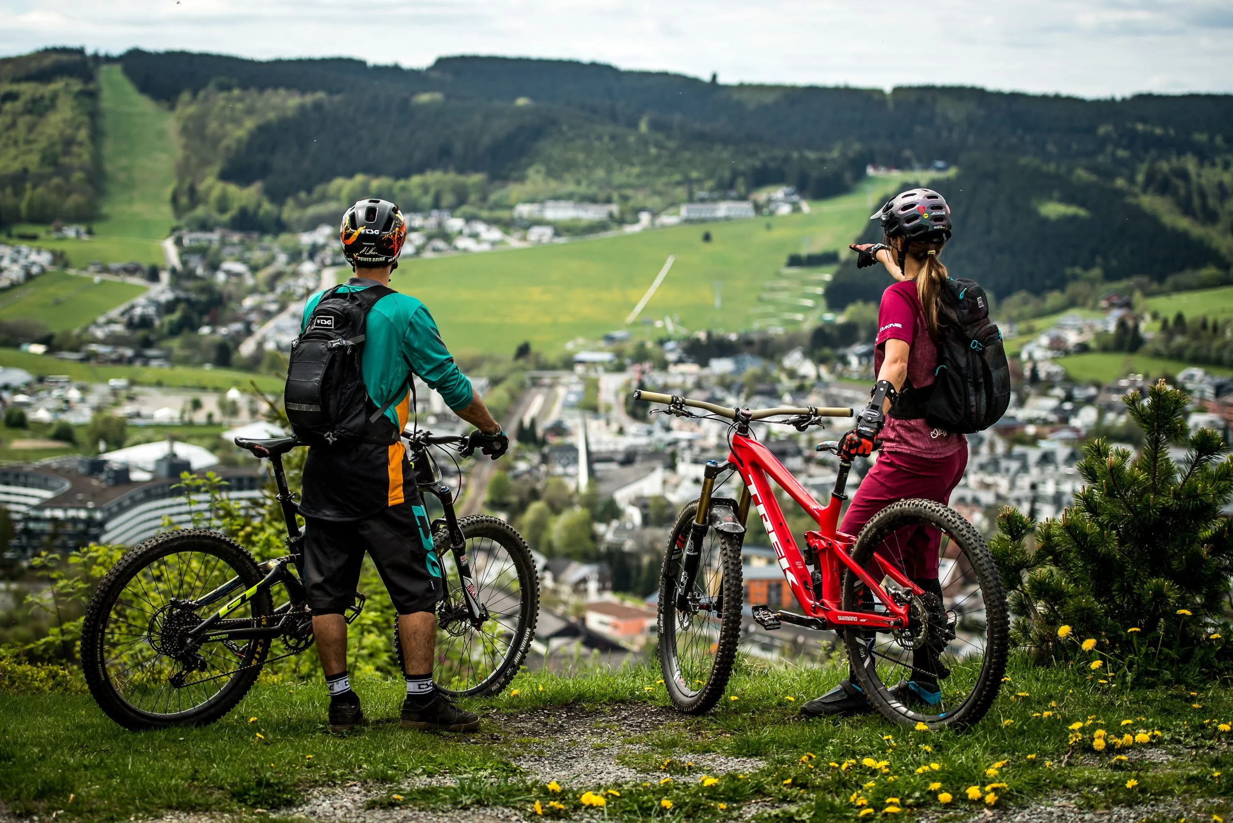 2 Mountainbiker stehen mit ihren Bikes auf dem Orenberg und schauen auf Willingen