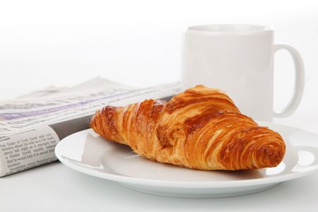 Frühstück mit Croissant, Kaffee und Zeitung