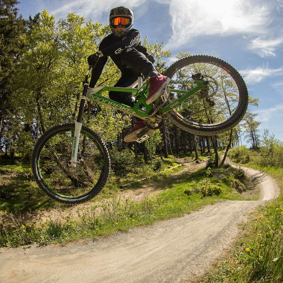 Biker bei einem spektakulären Sprung auf der Freeridestrecke im MTB Zone Bikepark Willingen