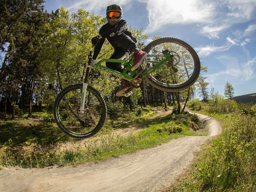 Biker bei einem spektakulären Sprung auf der Freeridestrecke im MTB Zone Bikepark Willingen