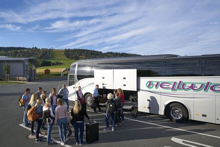 Reisegruppe vor einem Bus am Fuß des Ettelsbergs