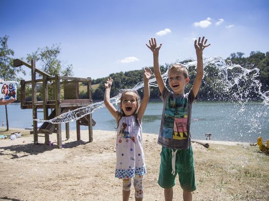 2 Kinder beim Spielen mit Wasser auf dem Spielplatz am Diemelsee