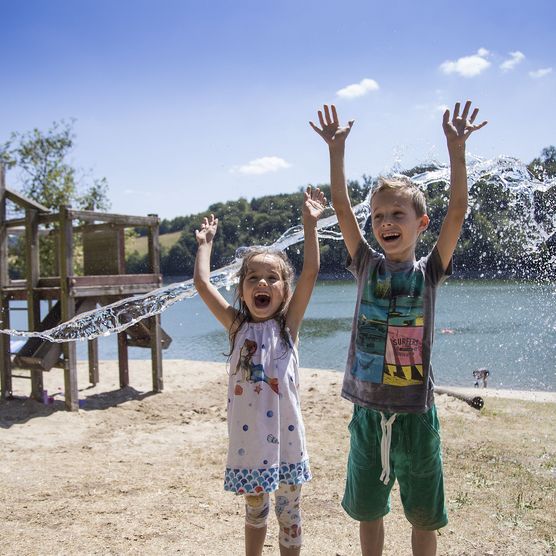 2 Kinder beim Spielen mit Wasser auf dem Spielplatz am Diemelsee