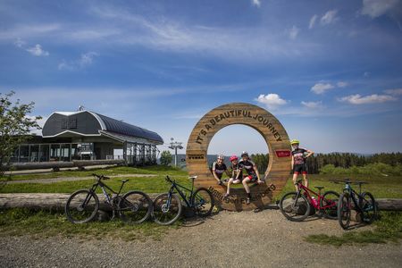 Eine Familie mit Mountainbikes macht Rast am Aussichtsturm auf dem Ettelsberg, im Hintergrund die Bergstation der Ettelsberg-Seilbahn