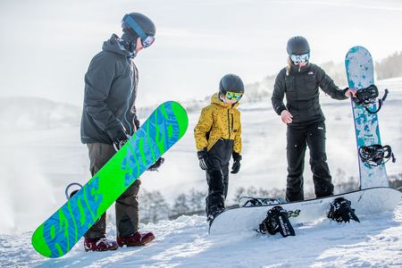 Familie mit Snowboards auf der Skipiste in Willingen