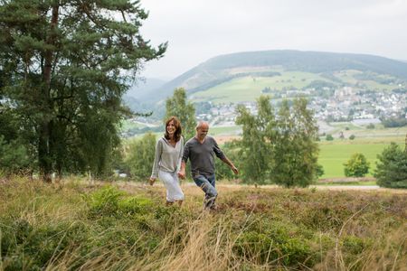 Paar spaziert am Hang des Ettelsbergs, im Hintergrund ist Willingen zu sehen