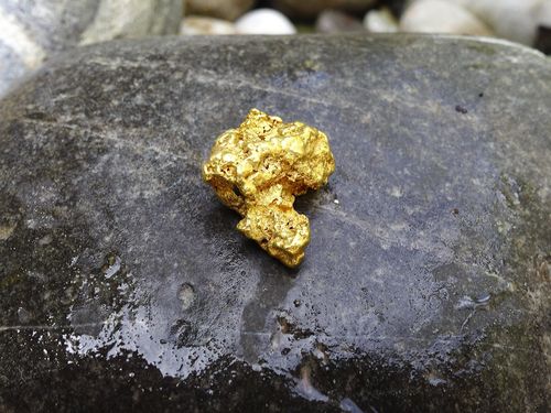 Goldnugget auf dunklem Stein