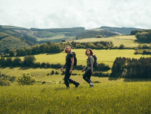 Paar wandert durch Wiesenlandschaft im Sauerland