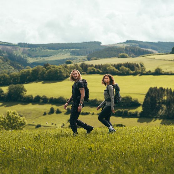 Paar wandert durch Wiesenlandschaft im Sauerland